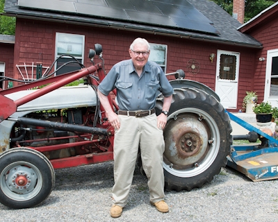 New England Forestry Foundation donor Ben Pratt stands in front of his tractor