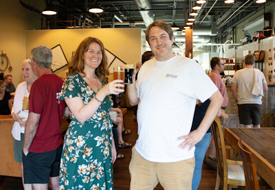NEFF Executive Assistant Meaghan Guyader and NEFF Conservation Easement Director Andrew Bentley cheers at the first All Spruced Up beer release event at Dirigible Brewing Company on July 26, 2023. Photo by Tinsley Hunsdorfer.